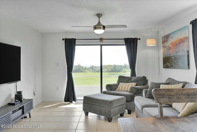 living area featuring a ceiling fan, a textured ceiling, and light tile patterned flooring