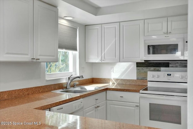 kitchen featuring white appliances, white cabinets, a sink, and light countertops