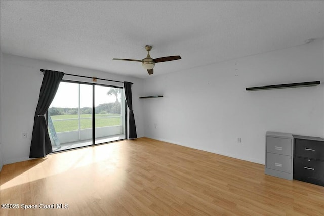 empty room with light wood-style floors, baseboards, a ceiling fan, and a textured ceiling