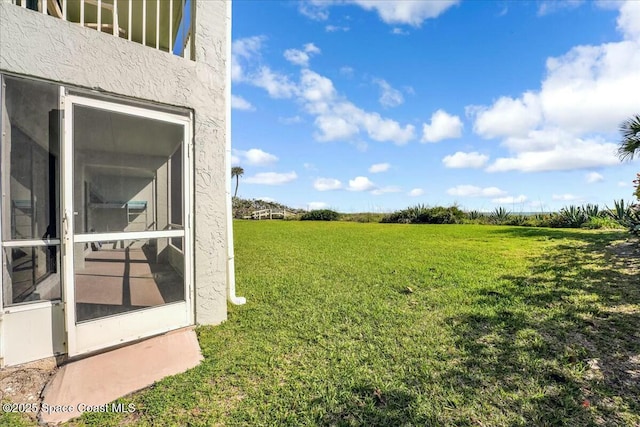 view of yard with a sunroom and a rural view