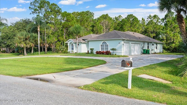 view of front of home featuring a garage, driveway, a front lawn, and stucco siding