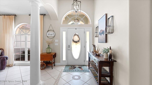 foyer entrance with light tile patterned floors and ornate columns