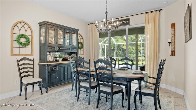 dining room featuring a notable chandelier, baseboards, and light tile patterned floors