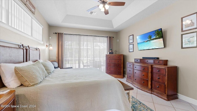 bedroom with light tile patterned floors, a raised ceiling, visible vents, access to outside, and baseboards