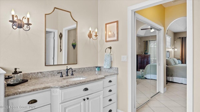 bathroom with ceiling fan, connected bathroom, vanity, and tile patterned floors