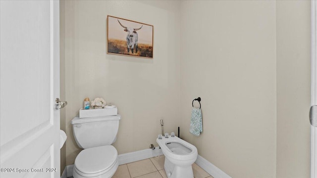 half bath with baseboards, a bidet, toilet, and tile patterned floors