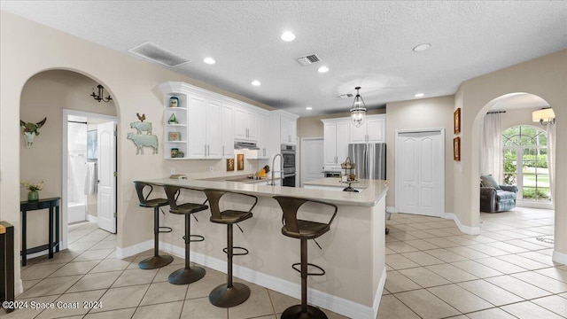 kitchen featuring a peninsula, visible vents, white cabinets, light countertops, and open shelves