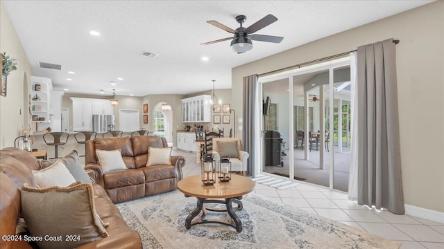 living room featuring light tile patterned floors, plenty of natural light, visible vents, and a ceiling fan