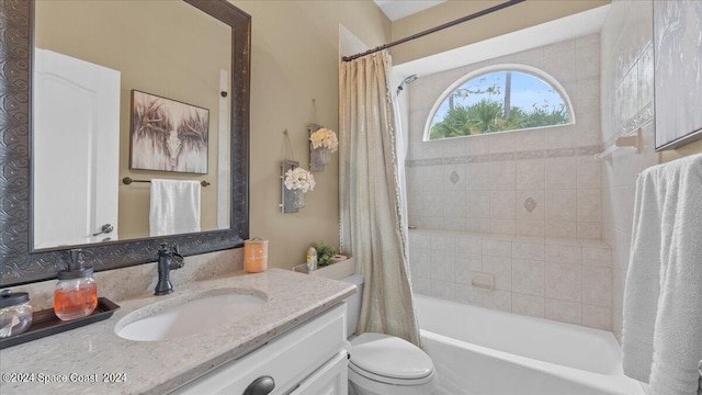 bathroom featuring toilet, shower / tub combo with curtain, and vanity