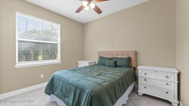 bedroom featuring light tile patterned flooring, a ceiling fan, and baseboards