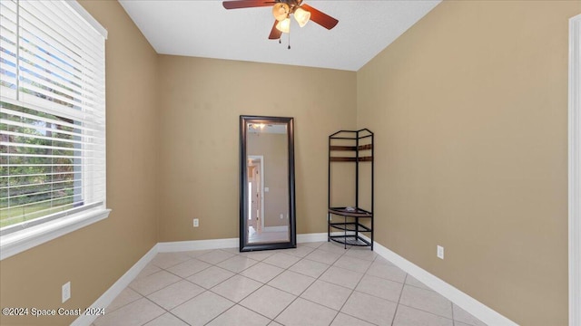 spare room with ceiling fan, baseboards, and light tile patterned flooring