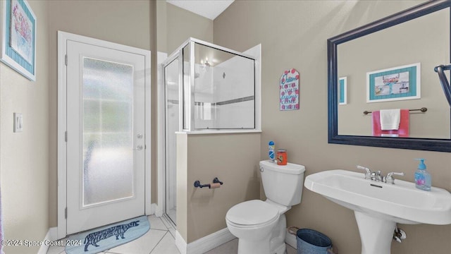 full bathroom featuring toilet, a shower stall, baseboards, and tile patterned floors