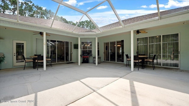 view of patio with ceiling fan, outdoor dining space, and a lanai