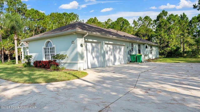 view of property exterior with a yard, concrete driveway, and stucco siding