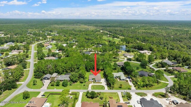 drone / aerial view featuring a residential view and a view of trees