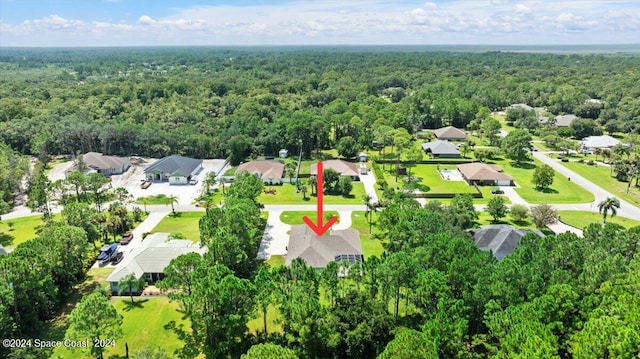 birds eye view of property featuring a forest view and a residential view