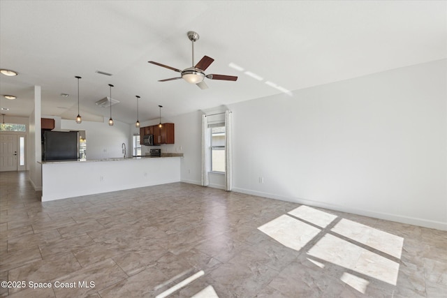 unfurnished living room with lofted ceiling, ceiling fan, a sink, visible vents, and baseboards