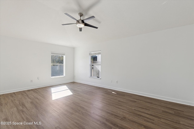 spare room featuring ceiling fan, baseboards, and dark wood-style flooring