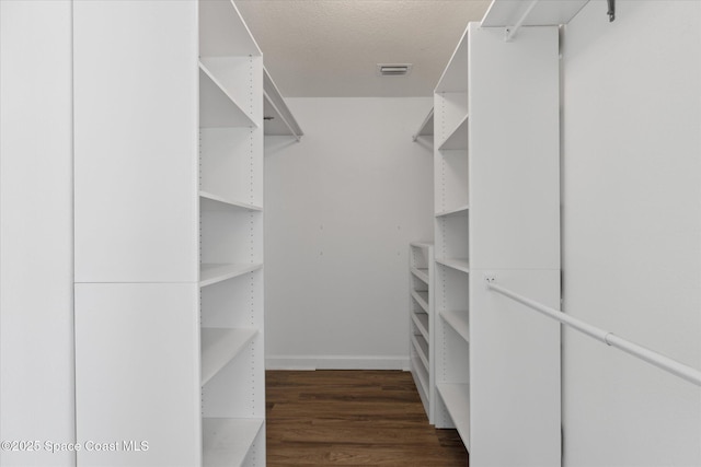 spacious closet featuring dark wood-style floors and visible vents