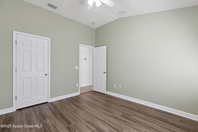 unfurnished bedroom with lofted ceiling, dark wood-style flooring, a ceiling fan, visible vents, and baseboards