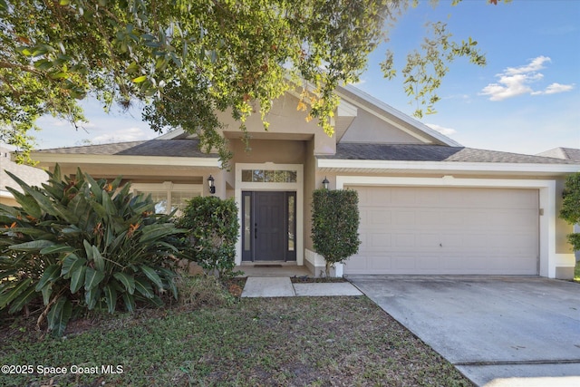 view of front of home featuring driveway, an attached garage, and stucco siding