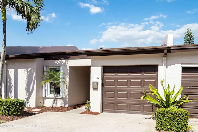 view of front of house with a garage, driveway, and stucco siding