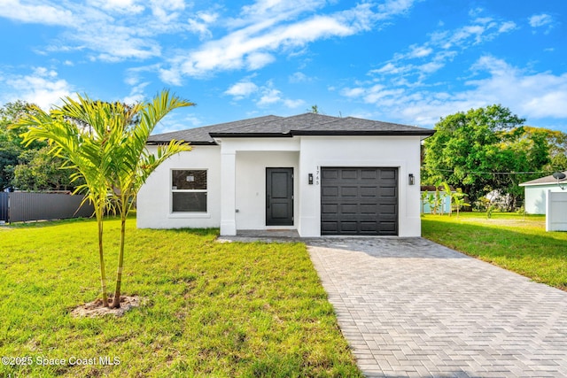 view of front of house with decorative driveway, stucco siding, an attached garage, a front yard, and fence