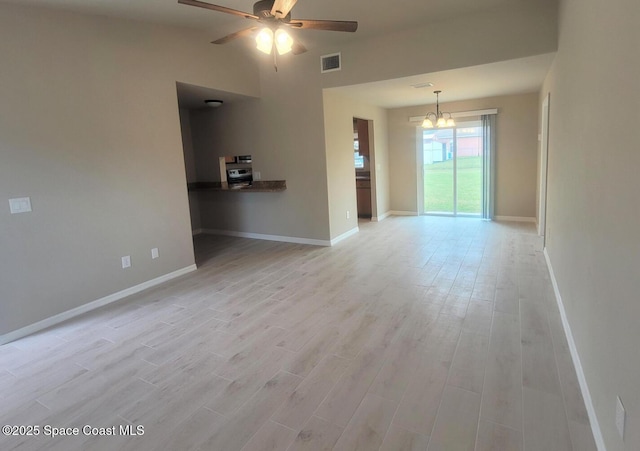 empty room with light wood-type flooring, visible vents, baseboards, and ceiling fan with notable chandelier