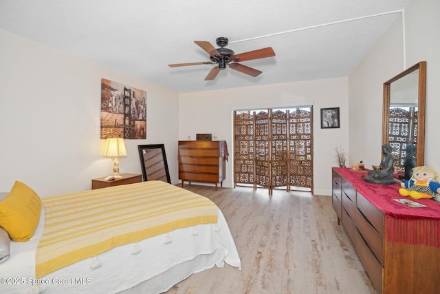 bedroom with light wood-style floors, ceiling fan, and access to outside