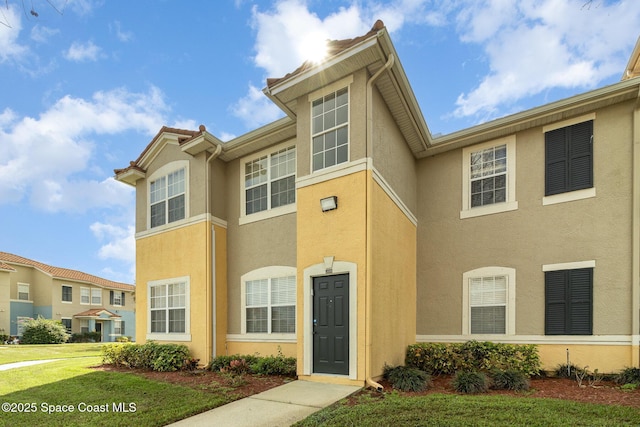 view of front of home with a front yard and stucco siding