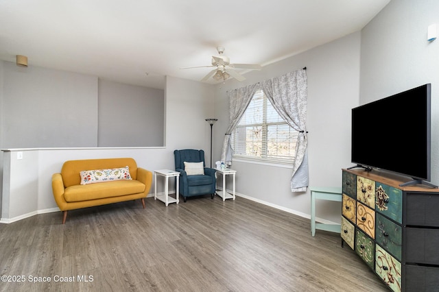 living area with ceiling fan, baseboards, and wood finished floors