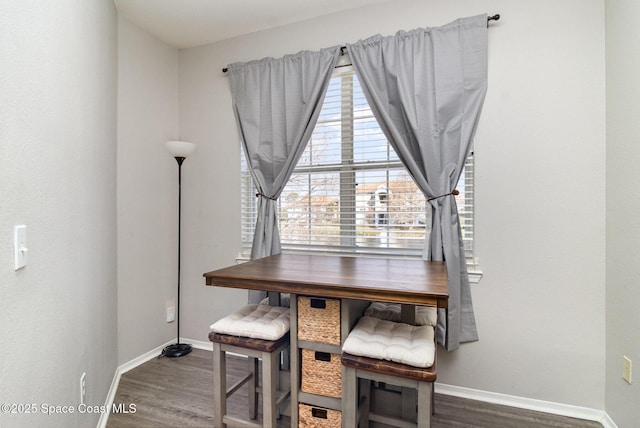 dining space with baseboards and wood finished floors