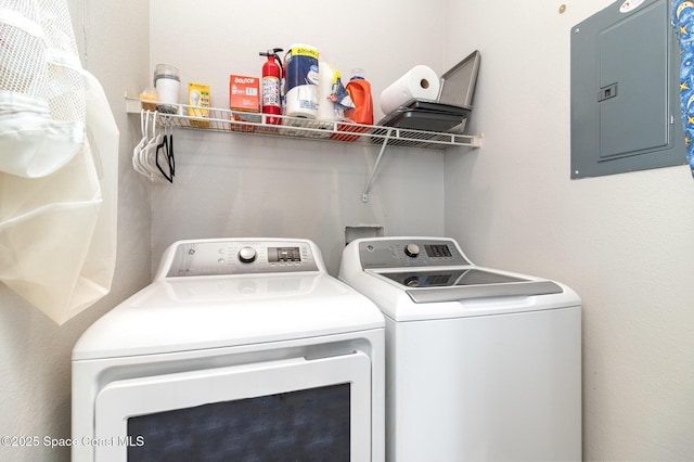 laundry room with laundry area, washing machine and clothes dryer, and electric panel