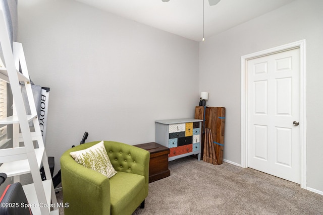 living area with carpet floors, baseboards, and a ceiling fan