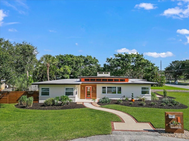 view of front facade featuring a front lawn, fence, and stucco siding