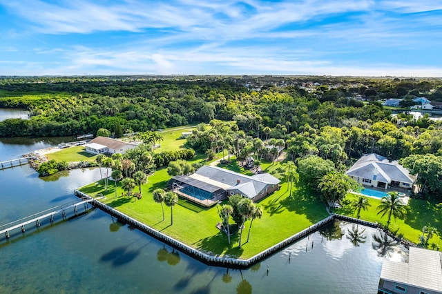 birds eye view of property with a water view and a wooded view