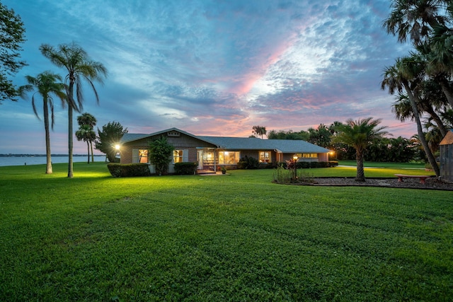 view of front facade with a front yard and a water view