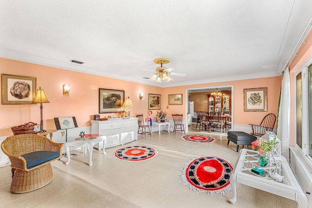 living area with ceiling fan with notable chandelier, visible vents, a textured ceiling, and ornamental molding