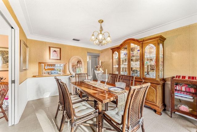 dining room featuring visible vents, crown molding, and an inviting chandelier