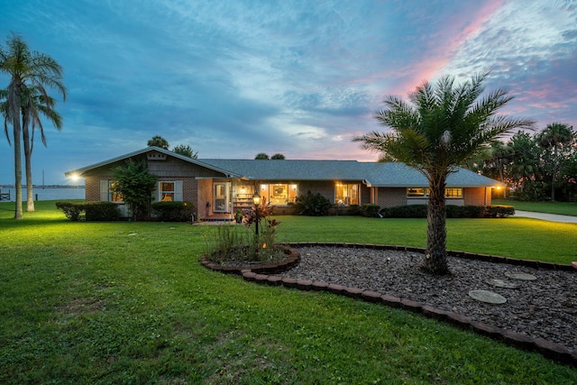 ranch-style home featuring a front lawn and brick siding