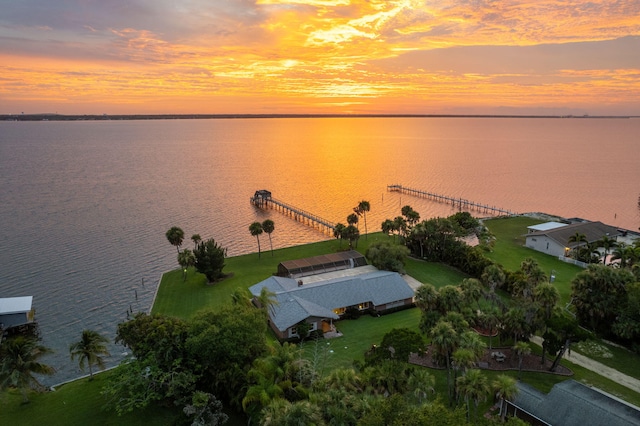 aerial view at dusk featuring a water view