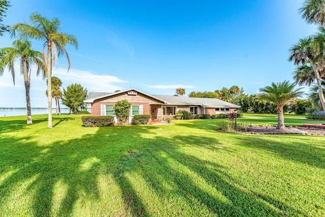 view of front facade with a front lawn and a water view