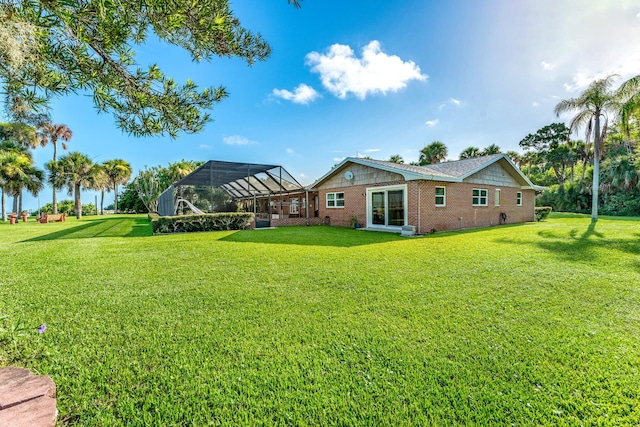 back of property featuring a lanai, brick siding, and a lawn