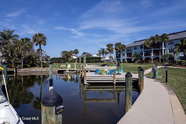 dock area with a lawn and a water view