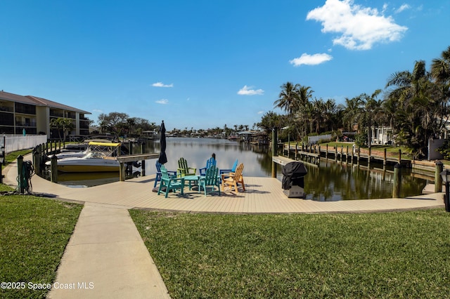 view of dock with a water view and a lawn