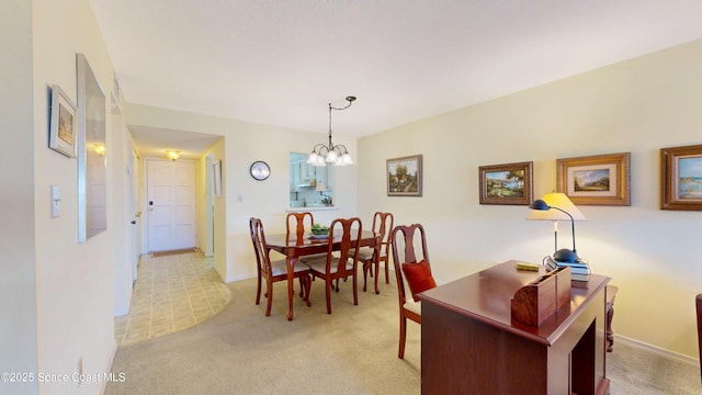 dining room featuring baseboards, an inviting chandelier, and light colored carpet