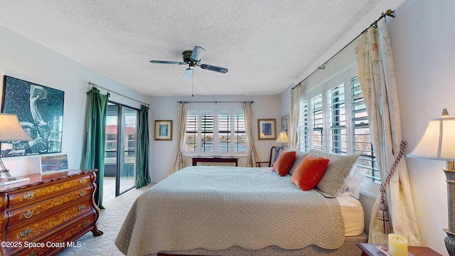 carpeted bedroom with a ceiling fan and a textured ceiling