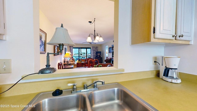 1999 S Banana River Blvd Unit 313, Cocoa Beach, FL 32931 - kitchen with a chandelier, light countertops, a sink, and white cabinets