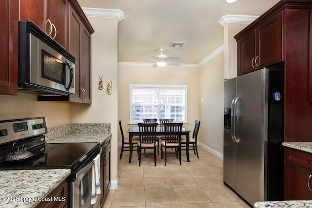 kitchen featuring visible vents, ornamental molding, light stone counters, stainless steel appliances, and light tile patterned flooring