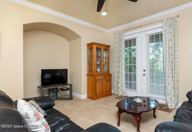 living room with light tile patterned floors, arched walkways, ceiling fan, ornamental molding, and french doors